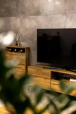 a living room with a flat screen tv on a wooden entertainment center at Exclusive place with underground parking and terrace in Oświęcim