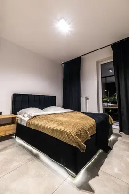 a bedroom with a large bed with a black headboard at Exclusive place with underground parking and terrace in Oświęcim