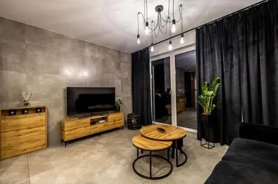 a living room with a table and a tv at Exclusive place with underground parking and terrace in Oświęcim