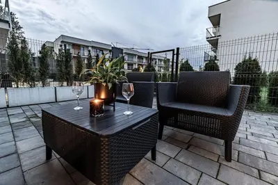 a table and chairs with wine glasses on a patio at Exclusive place with underground parking and terrace in Oświęcim