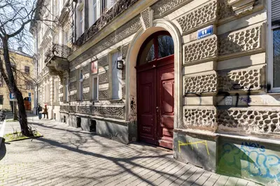 a red door on the side of a building at Park Krakowski Loft Apartment by BookingHost in Kraków