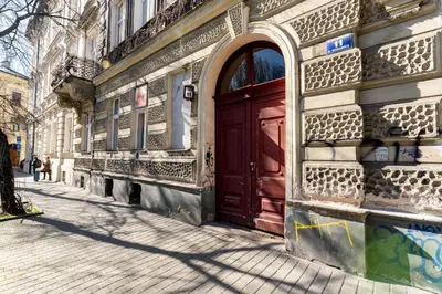 a red door on the side of a building at Park Krakowski Loft Apartment by BookingHost in Kraków