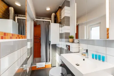 a bathroom with a white sink and a toilet at Park Krakowski Loft Apartment by BookingHost in Kraków