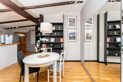 a dining room with a white table and chairs at Park Krakowski Loft Apartment by BookingHost in Kraków