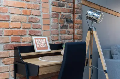 a table with a camera on a tripod next to a brick wall at Park Krakowski Loft Apartment by BookingHost in Kraków