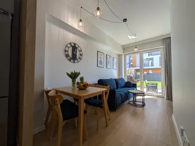 a living room with a table and a blue couch at Magic Apartments - Zibi in Zator