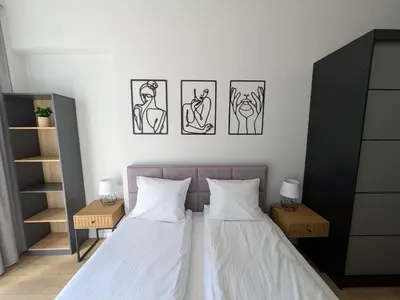 two beds in a bedroom with three pictures on the wall at Magic Apartments - Zibi in Zator