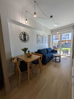 a living room with a table and a blue couch at Magic Apartments - Zibi in Zator