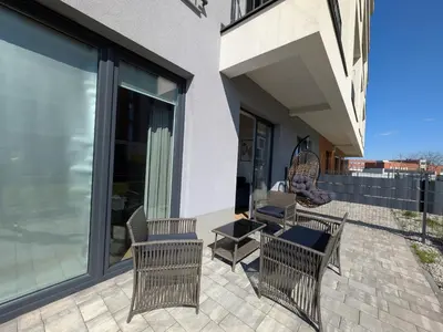 a patio with chairs and a table on a building at Magic Apartments - Zibi in Zator