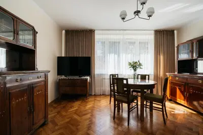 a dining room with a table and chairs and a television at Native Apartments Fałata 12 in Kraków