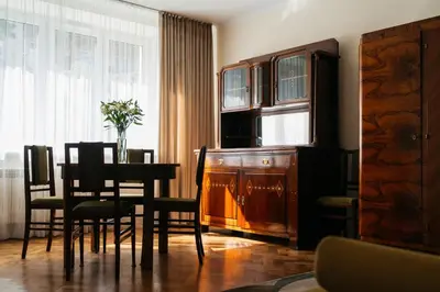 a dining room with a table and chairs and a window at Native Apartments Fałata 12 in Kraków