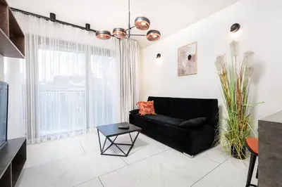 a black couch in a living room with a window at City of the Kings-Copper Nest in Kraków