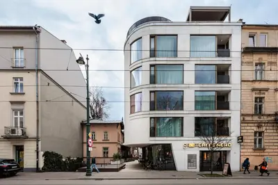 a building on a street with a bird flying over it at City of the Kings-Copper Nest in Kraków