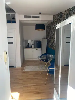 a living room with a table and a kitchen at Queen Bee Apartments Cracow Old Town in Kraków