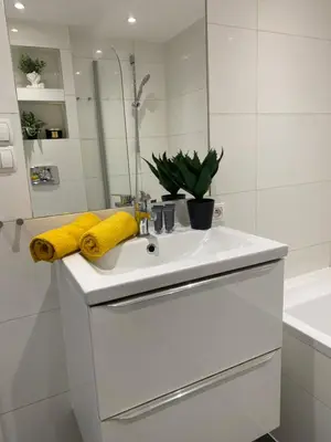 a white bathroom with a sink and a mirror at Queen Bee Apartments Cracow Old Town in Kraków