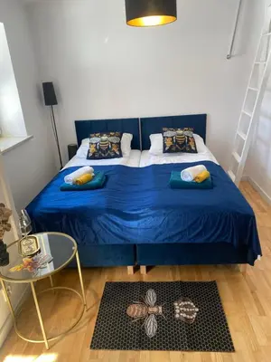 a bedroom with a blue bed and a glass table at Queen Bee Apartments Cracow Old Town in Kraków