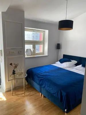 a bedroom with a blue bed and a glass table at Queen Bee Apartments Cracow Old Town in Kraków