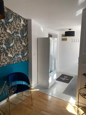 a room with a refrigerator and a blue chair at Queen Bee Apartments Cracow Old Town in Kraków
