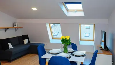a living room with a table and blue chairs at Scandi-Style Escape in Krakow in Kraków