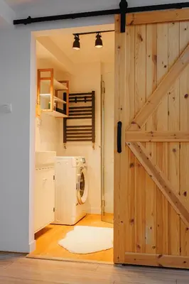 a door leading into a laundry room with a washing machine at Scandi-Style Escape in Krakow in Kraków