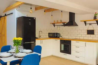 a kitchen with a table and a black refrigerator at Scandi-Style Escape in Krakow in Kraków
