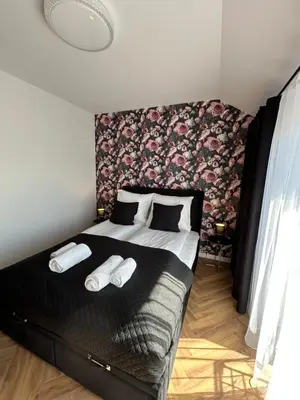 a bedroom with a large bed with a floral wall at DS Apartamenty Zator in Zator