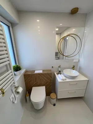 a bathroom with a toilet and a sink and a mirror at DS Apartamenty Zator in Zator