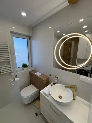 a bathroom with a sink and a toilet and a mirror at DS Apartamenty Zator in Zator