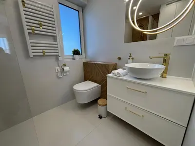 a white bathroom with a sink and a toilet at DS Apartamenty Zator in Zator