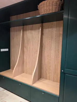 a display cabinet with wooden shelves in a room at Płachtówka in Słupia