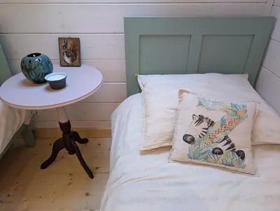 a bed with a pillow on it with a table at Płachtówka in Słupia