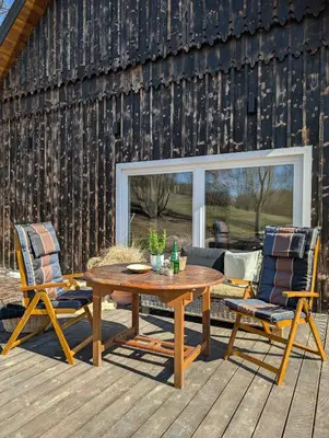 a patio with a wooden table and two chairs at Płachtówka in Słupia