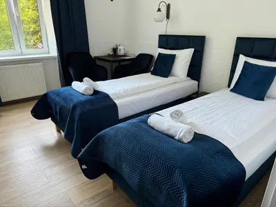 a hotel room with two beds and a table at Apartments Iris-Topolowa in Kraków