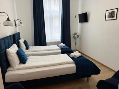 two beds in a room with blue and white at Apartments Iris-Topolowa in Kraków
