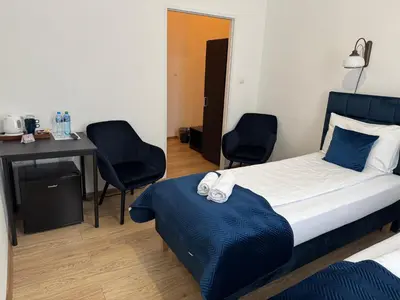 a bedroom with a bed and two chairs and a desk at Apartments Iris-Topolowa in Kraków