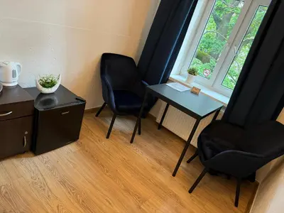 a room with two chairs and a table and a window at Apartments Iris-Topolowa in Kraków