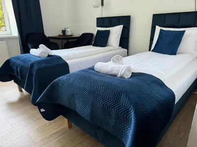 two beds in a room with blue and white at Apartments Iris-Topolowa in Kraków