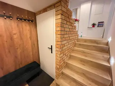 a staircase with a brick wall and a door at Agroturystyka Pod Jałowcem in Stryszawa