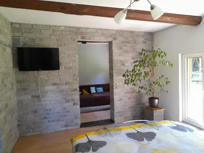 a bedroom with a brick wall with a tv at Domek Na Skraju Lasu in Wola Batorska