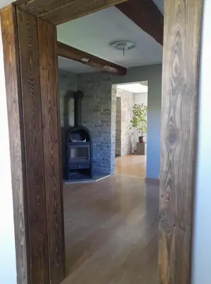 an open living room with a stone fireplace at Domek Na Skraju Lasu in Wola Batorska
