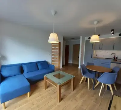 a living room with a blue couch and a table at Apartament Salwator in Kraków