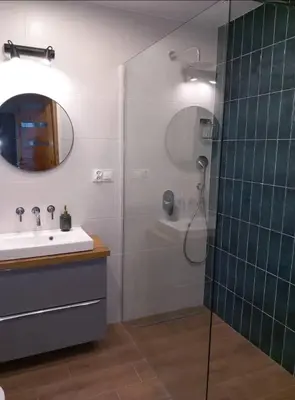a bathroom with a shower and a sink and a mirror at Apartament Salwator in Kraków