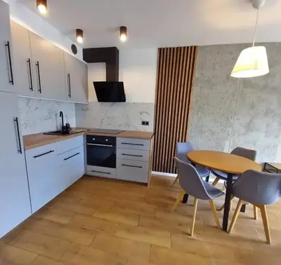a kitchen with a table and chairs and a dining room at Apartament Salwator in Kraków
