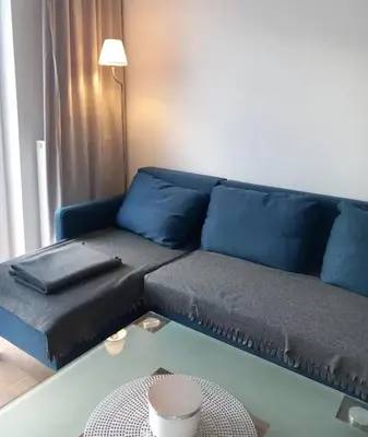 a blue couch in a living room with a table at Apartament Salwator in Kraków