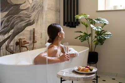 a woman sitting in a bath tub holding a glass of wine at OLD TOWN Charm & Chic by Downtown Apartments in Kraków