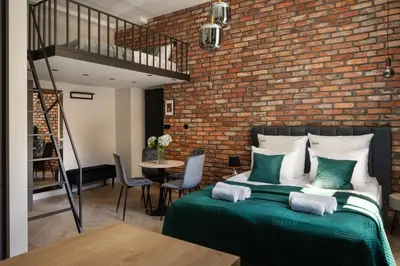a bedroom with a bed and a brick wall at OLD TOWN Charm & Chic by Downtown Apartments in Kraków