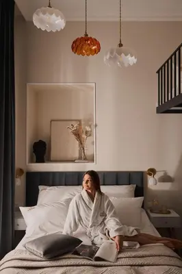 a woman sitting on a bed in a bedroom at OLD TOWN Charm & Chic by Downtown Apartments in Kraków