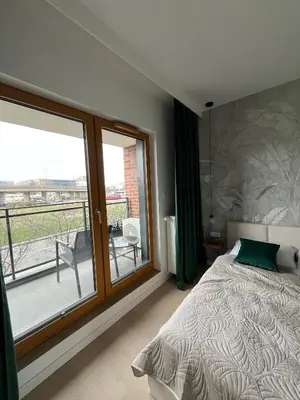 a bedroom with a bed and a large window at Tropical Novum Apartment - Krakow Old Town in Kraków