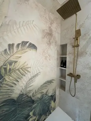 a bathroom with a mural of leaves on the wall at Tropical Novum Apartment - Krakow Old Town in Kraków