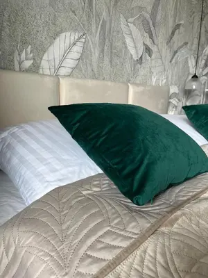 a green pillow sitting on top of a bed at Tropical Novum Apartment - Krakow Old Town in Kraków